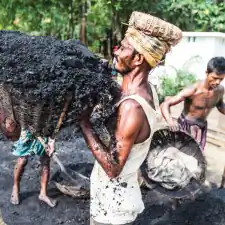 Man lifting a basket full of coal, Charkawa village, East Side of Kirtonkhola River, Barisal, Barisal District, Bangladesh, Indian Sub-Continent, Asia.