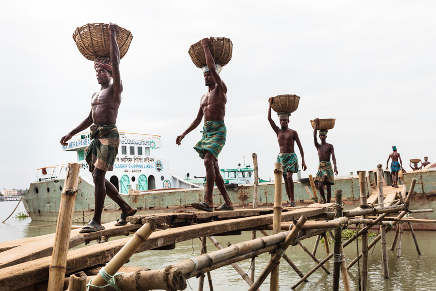 Bangladeshi men unloading goods from a river ship, a river quay on the east bank of Kirtonkhola River, Barisal District, Bangladesh, Indian Sub-Continent, Asia