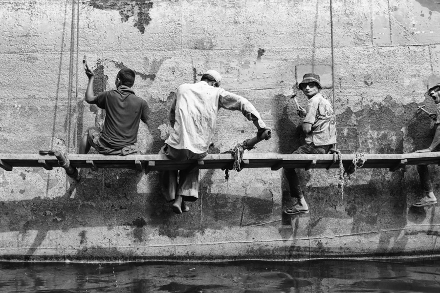 Men hammering away on the metal of the big ship at Dhaka Shipyard, Dhaka, Bangladesh, Indian Sub-Continent, Asia.