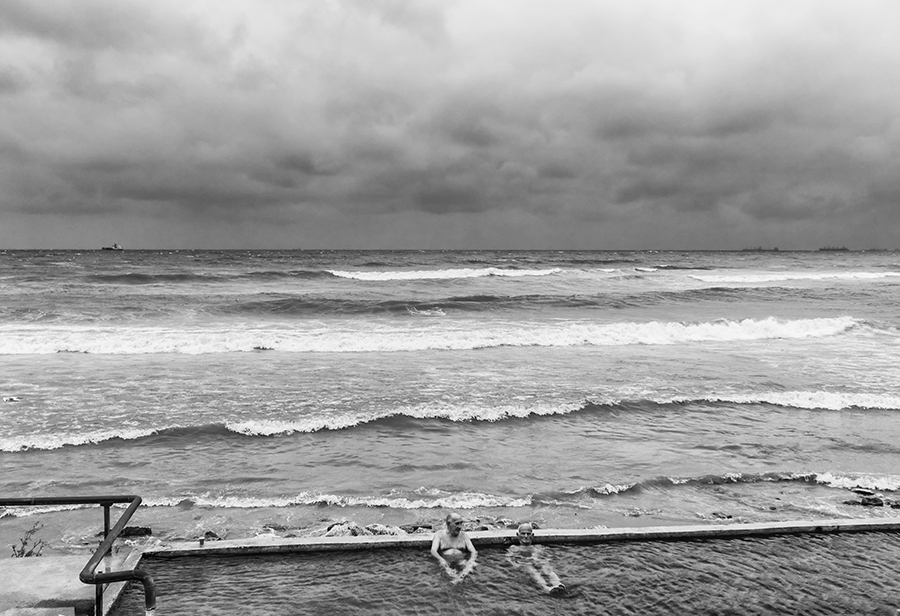 Two guys enjoying the hot mineral water source on the beach in Varna, Bulgaria