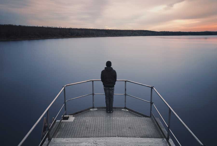 young man standing on lake