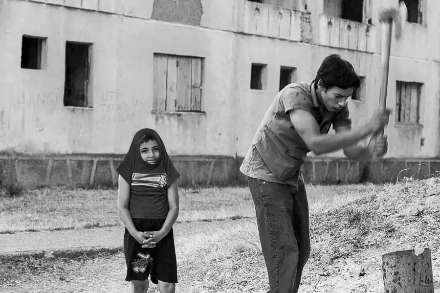 Pavel (left) stand in the rain with a friend who splits logs to be used for the coming winter.