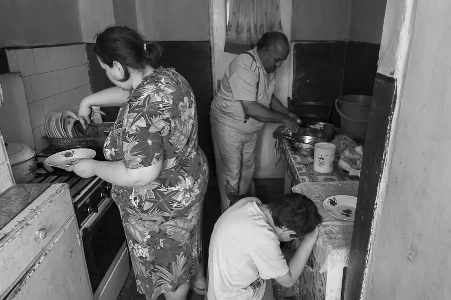 Ion Cojocea with his daughter and one of his grandchildren, preparing lunch in the kitchen of the apartment.
