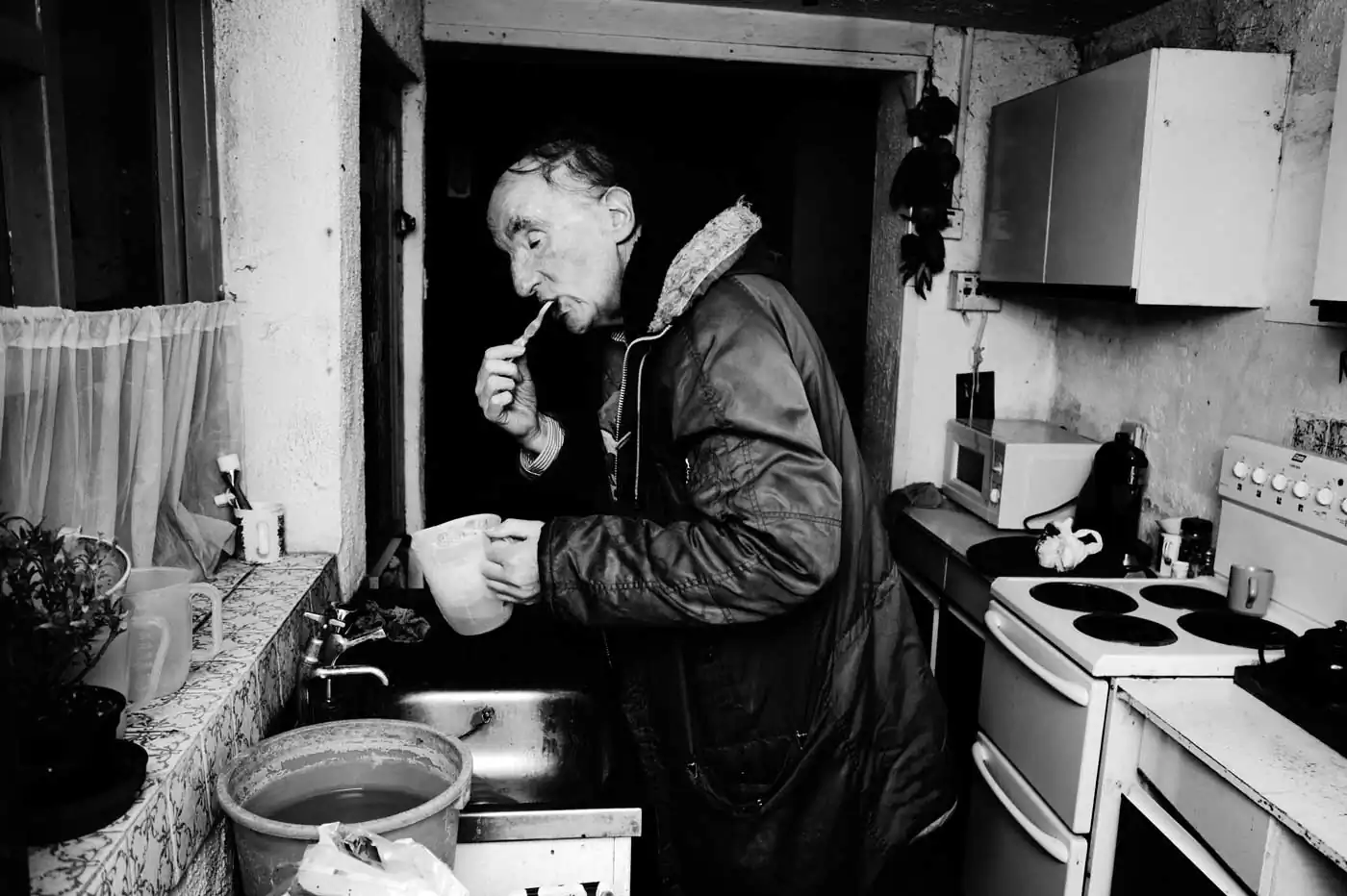 David brushing his teeth in the kitchen sink before embarking on his daily walk.