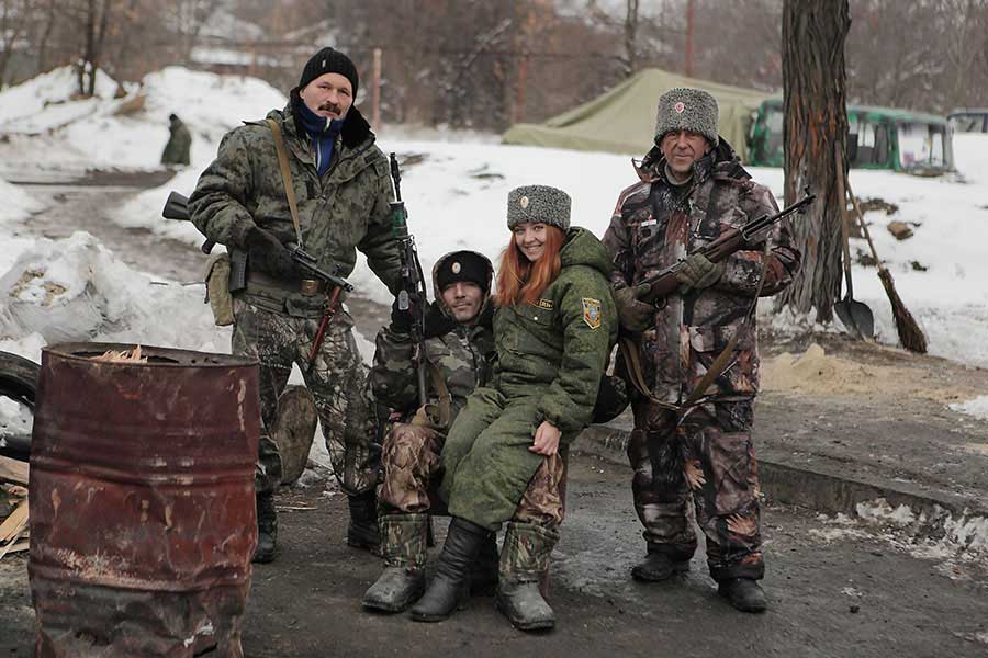 Cossack family - a father, a son and his girlfriend and a grandfather pose for a family photo on the rebels' check-point. The war-torn Donetsk and Luhansk regions, with their industrial factories, coal mines and steel mills, until recently comprised 16% of Ukraine's GDP. Now workers, such as this cossack Gennady, 58, have turned their ancient guns against Kiev' governement, December 08 2014, Pervomaisk, Eastern Ukraine. Photographer: Dmitry Beliakov/ for Der Spiegel