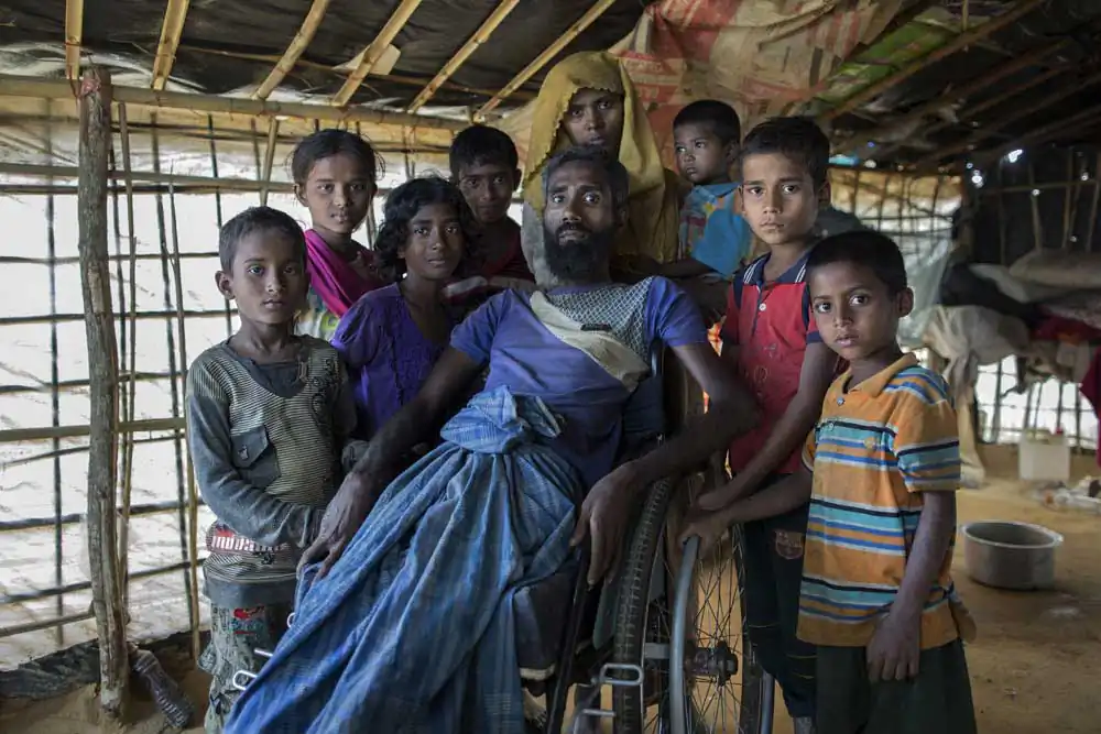 A portrait of Mohammad Alamgir, 40, and his family. Mohammad disabled due to polio, fled with his family from recent violence in Myanmar, and has taken shelter in Kutupalong refugee camp, Cox’s bazar.