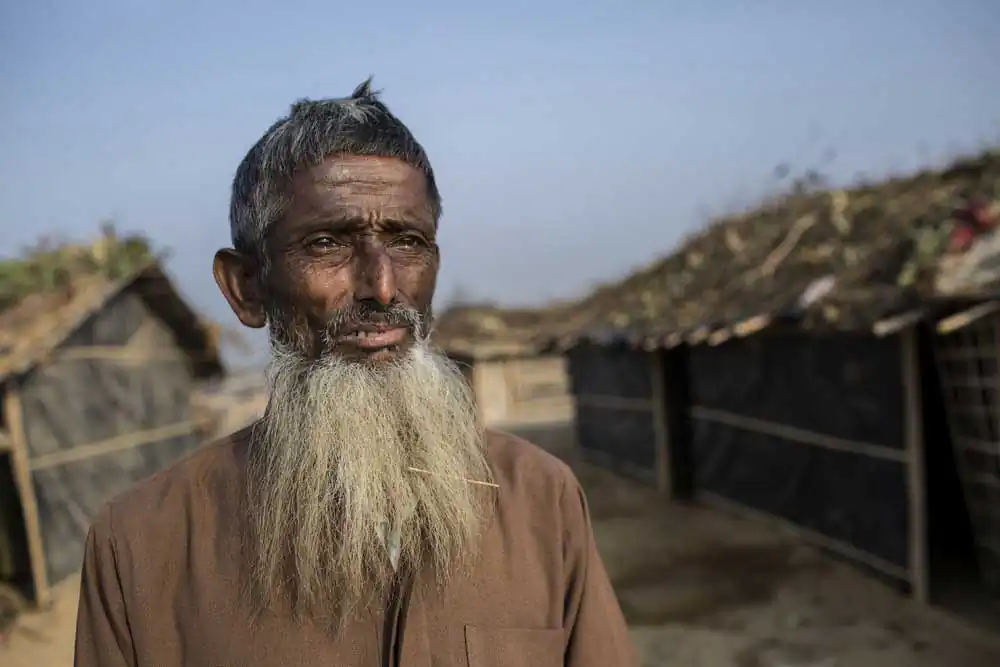 Abdul Salam,65, who fled from violence in Myanmar, stands in front of his makeshift home in Kutupalong newly expanded Rohingya refugee camp.