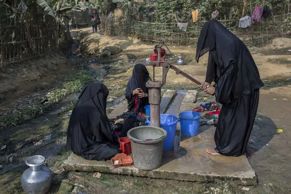 Rohingya women who fled from violence in Myanmar wash clothes in Kutupalong refugee cam, cox’s bazar. They always wear hijab when go outside to work.